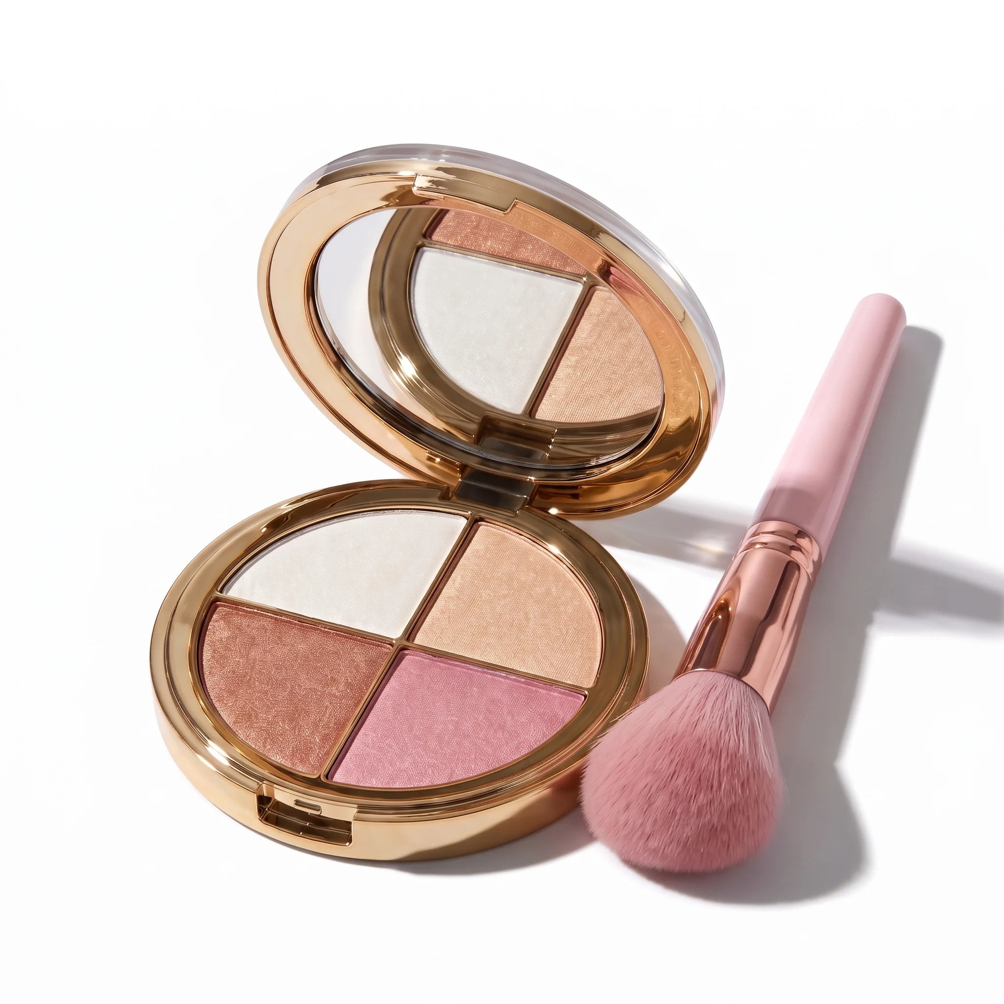 Makeup palette with four colors and a pink brush on a white background